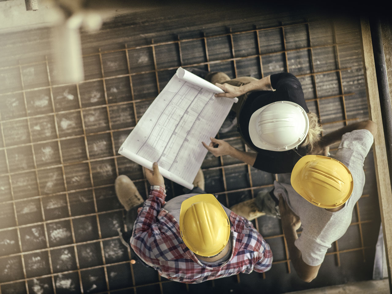 Female architect and two consruction workers on a construction site